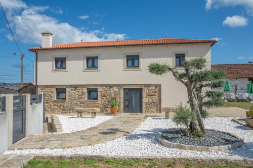 a house with a tree in front of it at Refúgio Da Gandra in Vila Nova de Cerveira