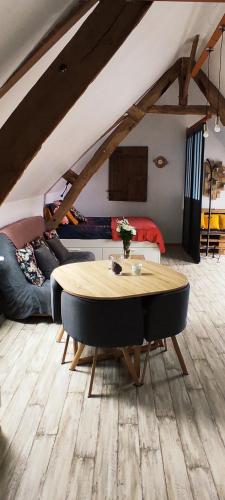 a living room with a table and a couch at La Manch'hôtes in Domjean