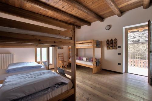 a bedroom with two bunk beds and a window at Rifugio Escursionistico La Ruà in Macra
