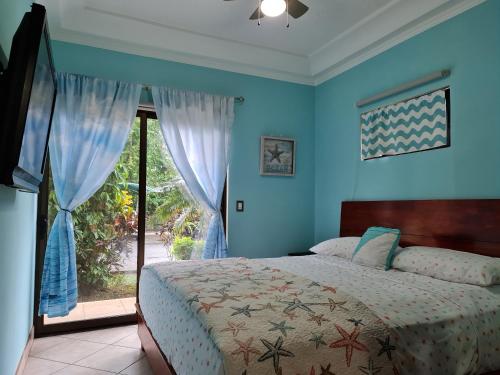 1 dormitorio con cama y ventana grande en The Oaks Tamarindo Primer piso, 22, 49, 73, en Tamarindo