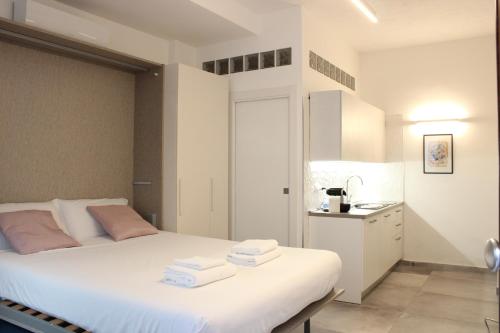 a bedroom with a white bed with towels on it at I Tre Cardilli in Matera