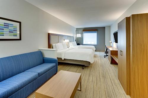 a hotel room with a bed and a couch at Holiday Inn Express Hotel and Suites Weatherford by IHG in Weatherford
