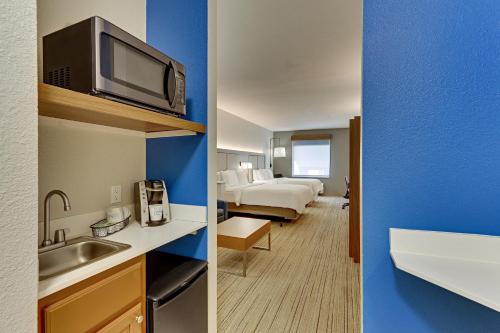 two views of a hotel room with a bed and a bathroom at Holiday Inn Express Hotel and Suites Weatherford by IHG in Weatherford