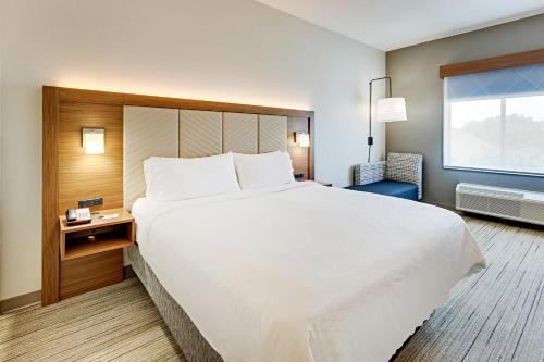 a large white bed in a room with a window at Holiday Inn Express Hotel and Suites Weatherford by IHG in Weatherford