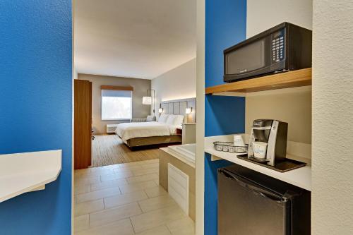 two views of a hotel room with a bed and a bathroom at Holiday Inn Express Hotel and Suites Weatherford by IHG in Weatherford