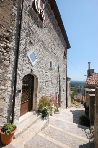 a stone building with a door and a window at L' Alcova Del Conte in Dragoni