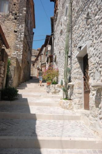 a woman walking down a street in an alley at L' Alcova Del Conte in Dragoni