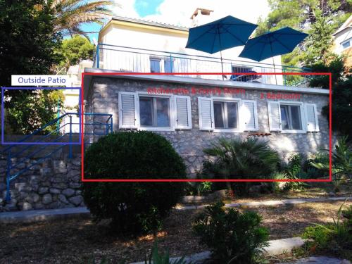 a building with two umbrellas on top of it at Casita Liliana By the Sea in Mali Lošinj