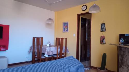 1 dormitorio con mesa, 1 cama y comedor en Kitnet Aurora, en Miguel Pereira