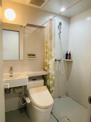 a bathroom with a toilet and a sink and a shower at Fujinomori Hotel in Fujikawaguchiko
