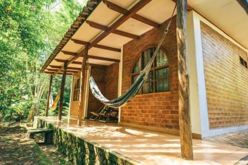 Huingos Eco Lodge في تارابوتو: شرفة منزل عليها أرجوحة