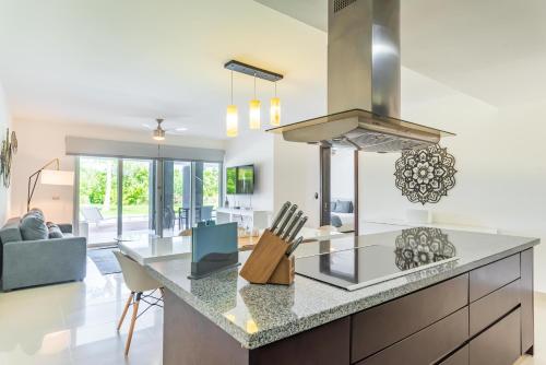 a kitchen and living room with a kitchen island with a stove at Mareazul Beach Front Condos At playa del Carmen in Playa del Carmen