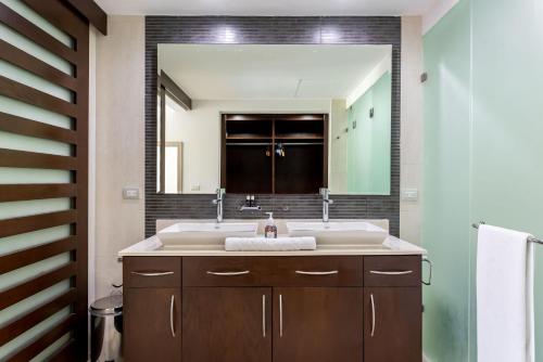 a bathroom with a sink and a large mirror at Mareazul Beach Front Condos At playa del Carmen in Playa del Carmen