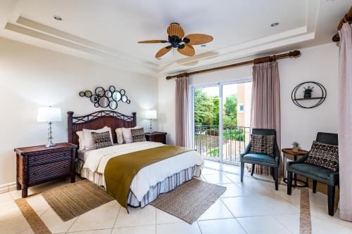een slaapkamer met een bed en een groot raam bij LUXURY 3BR appt, CENTER, 2 min to BEACH, hi-speed wifi in Tamarindo