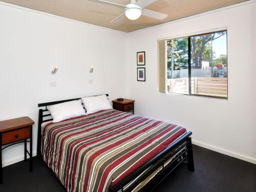 a bedroom with a bed and a window at Providence Apartment 3 in Hawks Nest