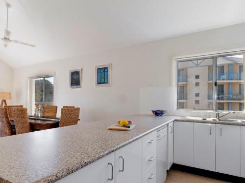 a kitchen with white cabinets and a counter top at Seachange Apartment 3 in Hawks Nest