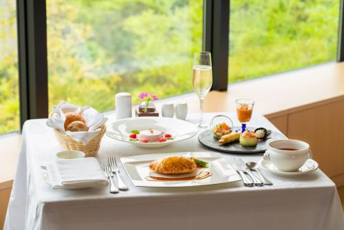 a table with food and drinks on a table with a window at The Hotel Seiryu Kyoto Kiyomizu - a member of the Leading Hotels of the World- in Kyoto