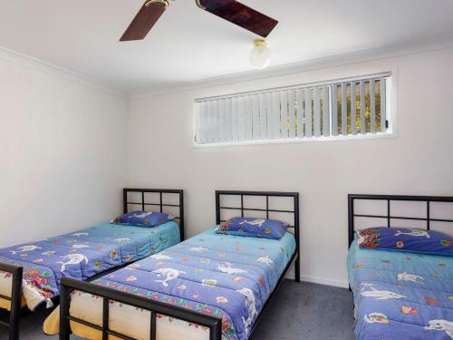 two twin beds in a room with a window at Three Bedroom Townhouse in Hawks Nest