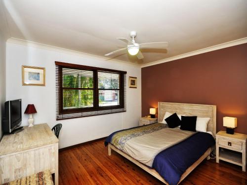 a bedroom with a bed and a ceiling fan at Brilliant Location in Tea Gardens