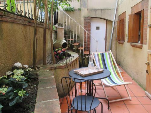 een patio met een tafel, 2 stoelen en een trap bij L' Appart in Toulouse