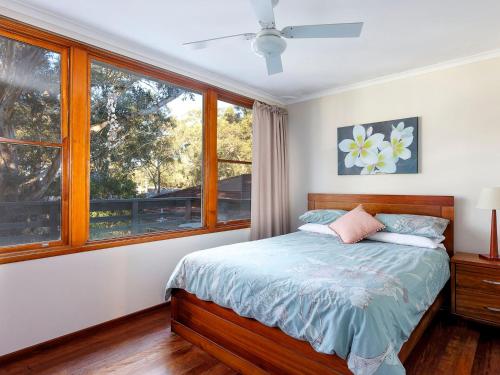 a bedroom with a bed and a window at Gumtree Cottage Hawks Nest in Hawks Nest