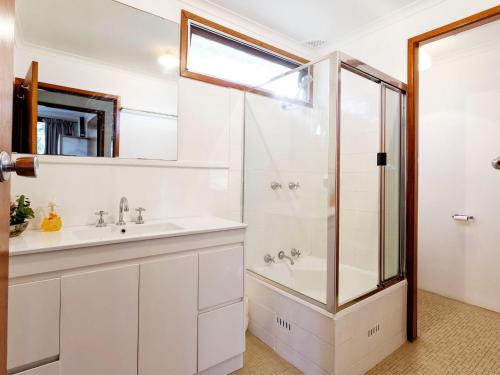 a bathroom with a sink and a shower at Gumtree Cottage Hawks Nest in Hawks Nest