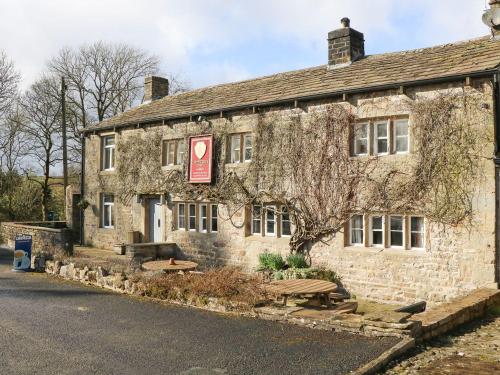 an old stone building with a sign on it at Austwick in Skipton