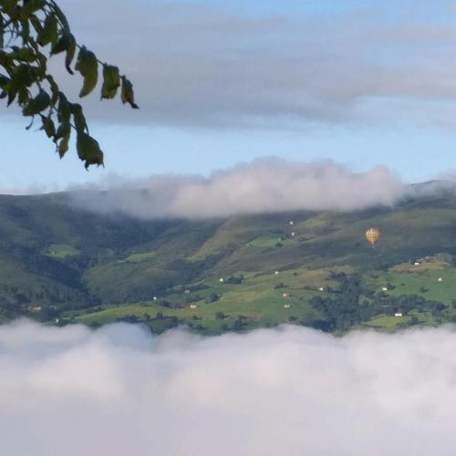 a hot air balloon flying above the clouds at Casuca Pico Jiniro in Abionzo