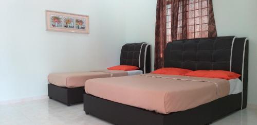 two beds in a room with two beds sidx sidx sidx sidx at Faris's Homestay & Resort in Pasir Puteh