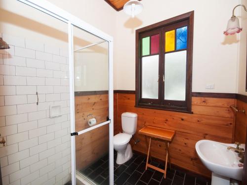 a bathroom with a toilet and a sink and a window at The Lakes Cottage in Tea Gardens