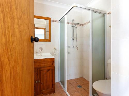 a bathroom with a shower and a sink and a mirror at Close To The Myall River Pet Welcome in Hawks Nest