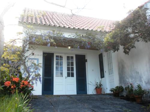 a white house with a black and white door at Casa do Areal in São Roque do Pico