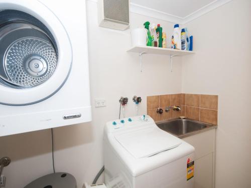 a bathroom with a washing machine and a sink at 4 Rio Vista in Hawks Nest