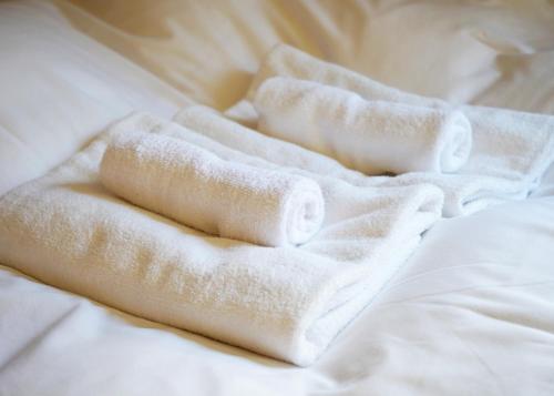 a pile of towels on a bed at 浅草ザ アパートメント Asakusa The Apartment in Tokyo