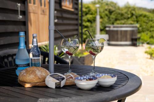 two glasses of wine and bread on a table at Daisy Park Shepherds Hut in Looe