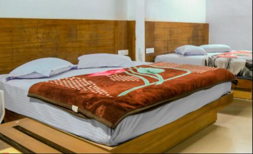 two beds in a hotel room with avertisement at WILLOW HILL LEISURE HOME in Munnar