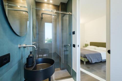 baño con lavabo y 1 cama en una habitación en Martina's Vineyard - rooms en Marsala