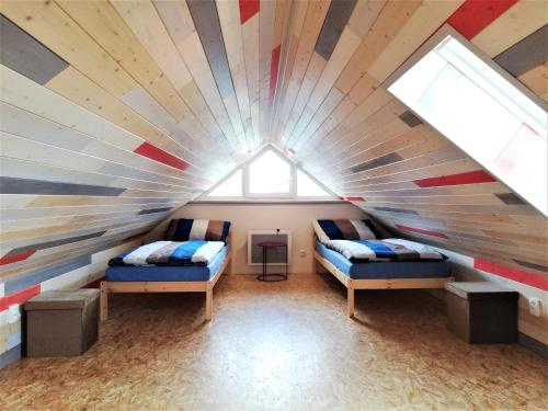 two beds in a room with a striped ceiling at Apartmány Pod Čápy, Nasavrky in Nasavrky