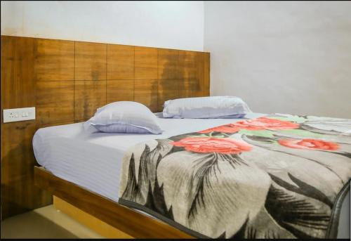 a bedroom with a large bed with red flowers on it at WILLOW HILL LEISURE HOME in Munnar