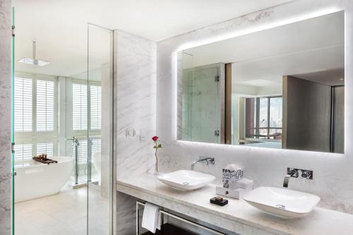 a bathroom with two sinks and a mirror at Paramount Hotel Dubai in Dubai