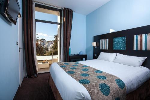Postel nebo postele na pokoji v ubytování Hôtel Baptistin
