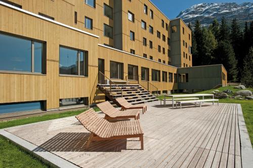 
a row of wooden benches in front of a building at St. Moritz Youth Hostel in St. Moritz
