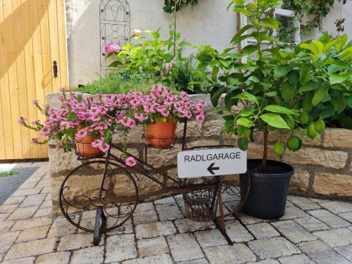 Zum Dallmayr Hotel Garni في برشينغ: عربة يوجد عليها الزهور والنباتات الفخارية