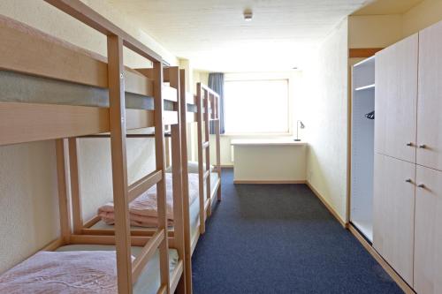 a dorm room with bunk beds and a window at St. Moritz Youth Hostel in St. Moritz