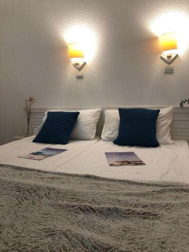 1 cama con 2 almohadas y 2 lámparas. en Résidence les Alcyons en Le Verdon-sur-Mer