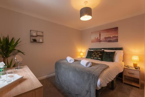 a bedroom with a large bed and a desk at 3 Bed Spacious Stylish House, Southampton - Off Road Parking & Private Garden - Sleeps 7, Close to City Centre - by Blue Puffin Stays in Southampton
