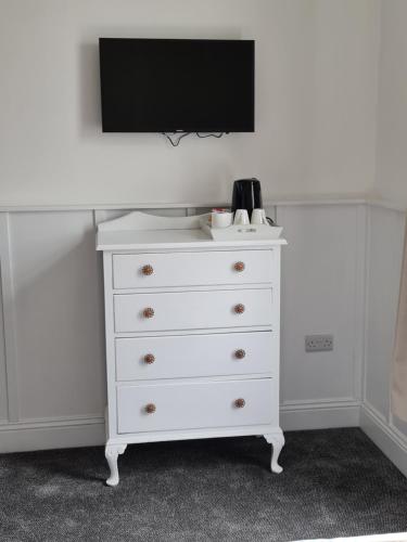 a white dresser with a television on top of it at The Selbourne Hotel in Scarborough