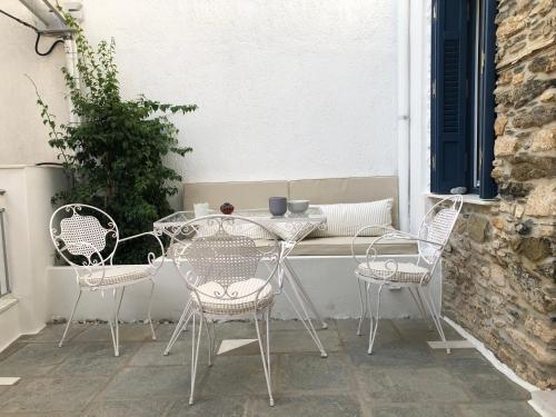 una mesa y sillas en un patio en Petra stonehouse near the Port, en Panormos Skopelos