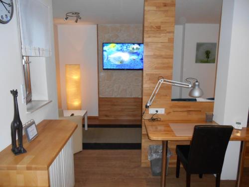 a room with a desk and a television on a wall at Warum ins Hotel in Neckarsulm