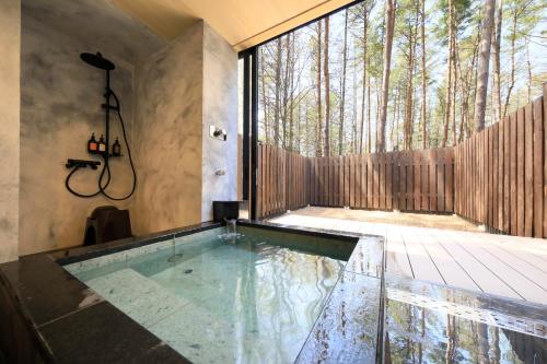 a swimming pool in the middle of a patio with trees at Yutorelo Tateshina Hotel with DOGS in Chino